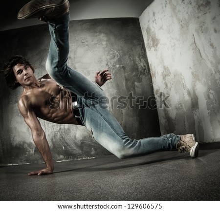 Young b-boy man with naked torso doing brake dancing movements