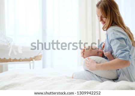Happy middle aged mother breast feeding her baby