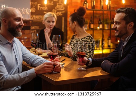Group of friends having fun talk behind bar counter in a cafe