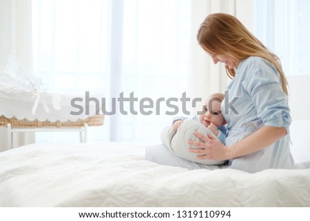 Happy middle aged mother with her child in a bed