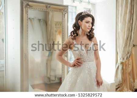 Beautifu bride choosing wedding dress in a wedding salon