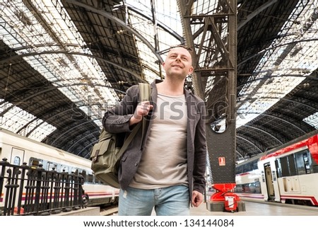 MIddle-aged traveler with backpack on train station platform