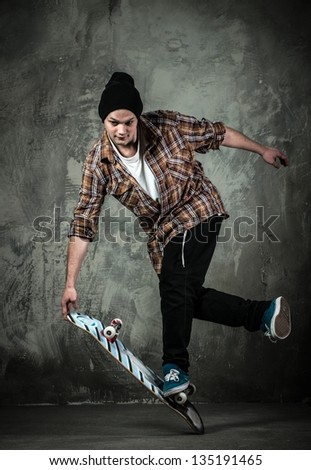 Young man in hat and shirt performing stunt on skateboard