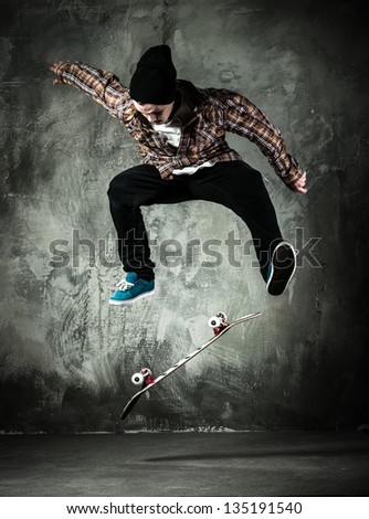 Young man in hat and shirt performing stunt on skateboard