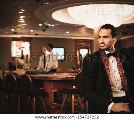 Handsome Brunette Wearing Suit In Luxury Casino Interior