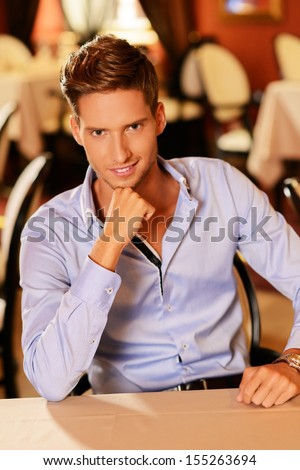 Handsome young man alone in a restaurant