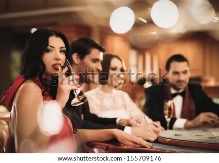 Group of young people playing poker in a casino Group of young people playing poker in a casino