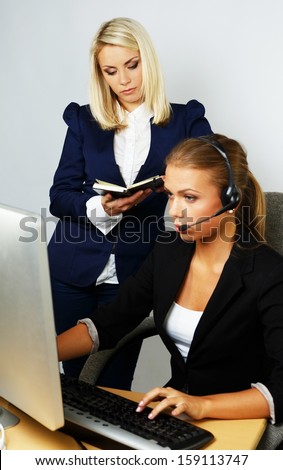 Beautiful help desk office support woman with female boss behind her