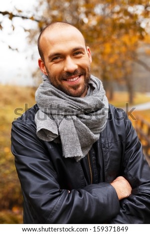Positive middle-aged man alone on beautiful autumn day