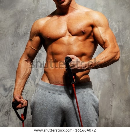 Handsome man with muscular body doing fitness exercise