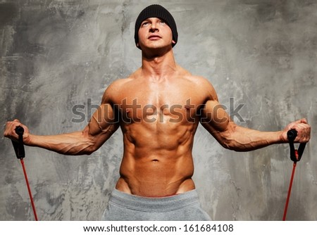 Handsome man with muscular body doing fitness exercise Handsome man with muscular body doing fitness exercise