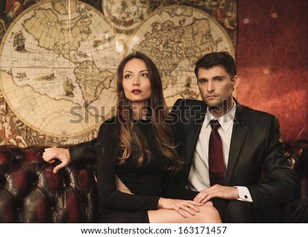 Beautiful Woman And Handsome Young Man Sitting On A Sofa In Luxury Interior