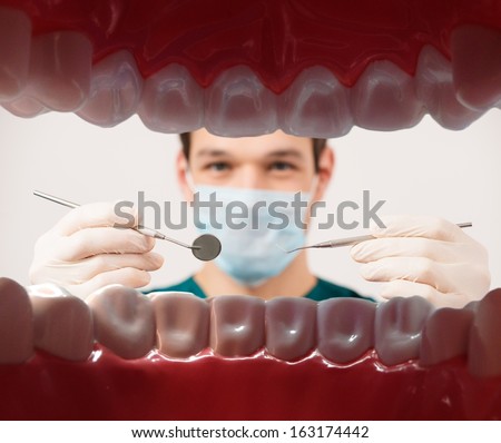 View At Young Male Dentist Holding Dental Tools From Patient Mouth