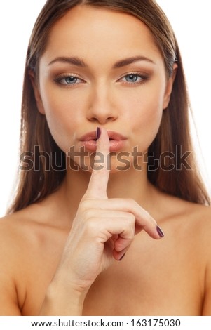Beautiful young brunette woman showing to keep silence sign