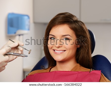 Dentist making anaesthetic injection to woman patient