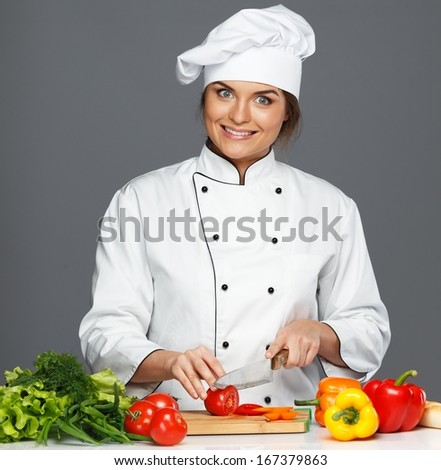 Funny mad young woman cook cutting fresh tomatoes