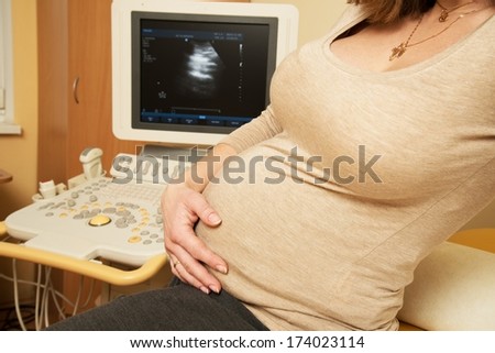 Young pregnant woman in ultrasound examination cabinet at hospital