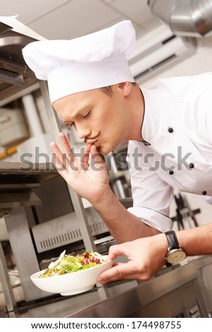 Young chief cook with gourmet food on kitchen in restaurant