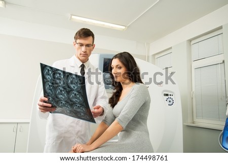 Doctor with young woman patient looking at the computed tomography results