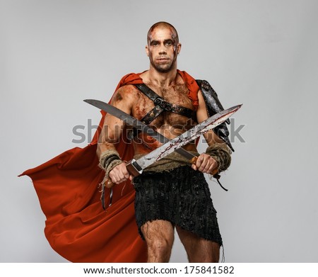 Wounded gladiator with two swords covered in blood isolated on grey