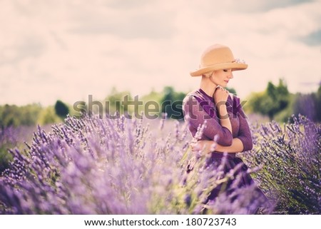 Woman in purple dress and hat in lavender field