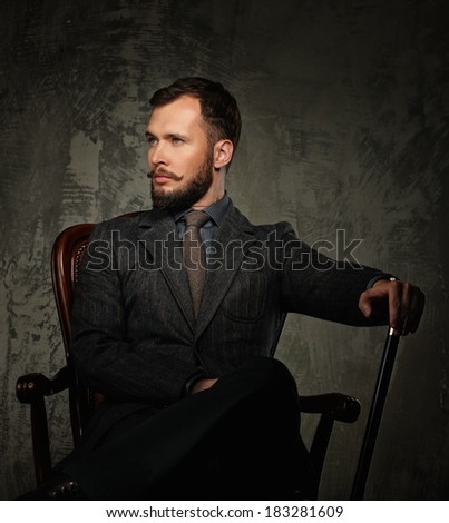 Handsome well-dressed with stick sitting in leather chair