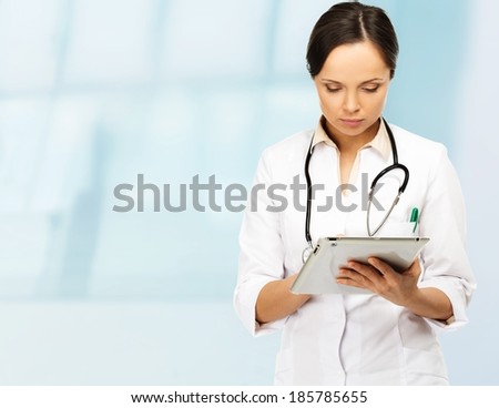 Young brunette doctor woman taking notes on tablet pc