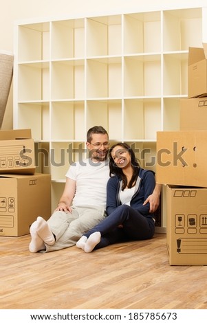 Young positive couple among boxes in their new home
