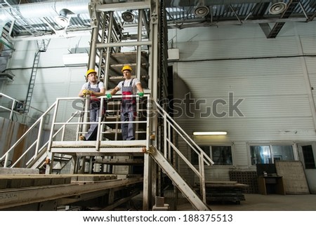 Two men in a safety hats on a factory