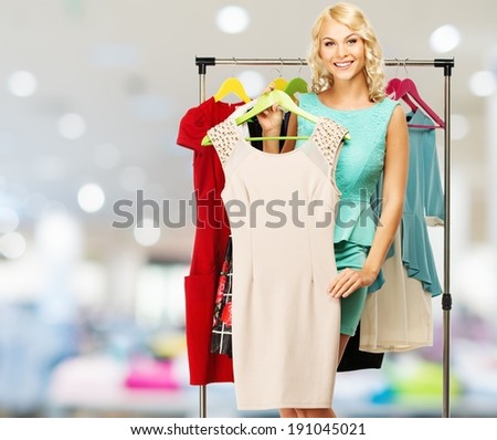 Smiling blond woman choosing clothes on a rack in a shopping mall