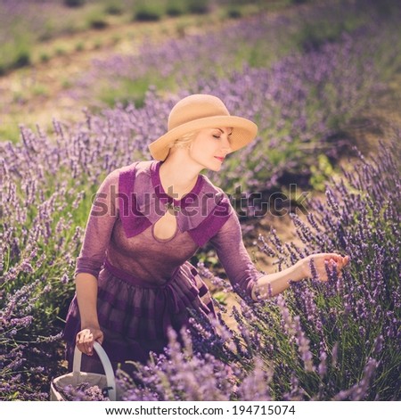 Woman in purple dress and hat with basket in lavender field