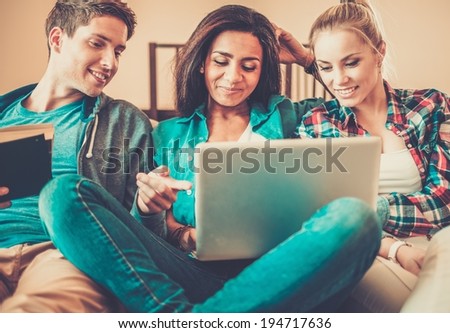 Three young students preparing for exams in home interior