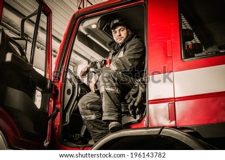 Fireman behind steering wheel of a firefighting truck