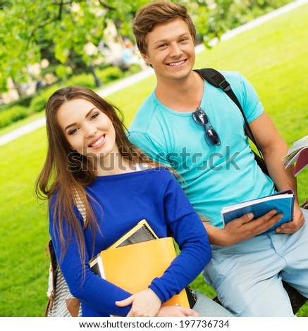 Students couple preparing for final exams in a city park
