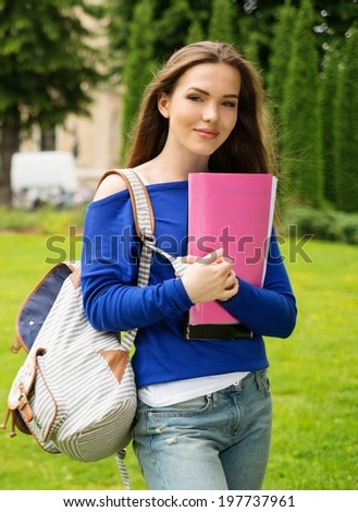 Beautiful young student girl in a city park on summer day
