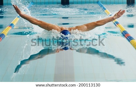 Young man in swimming cap and goggles swim using breaststroke technique