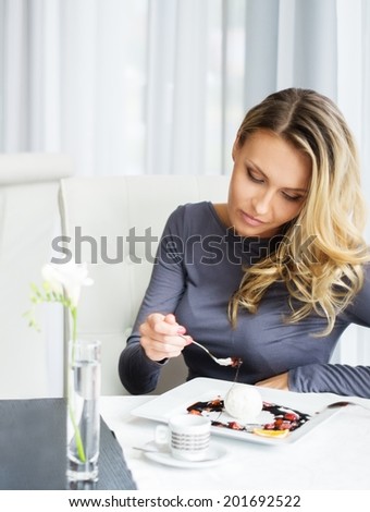 Woman alone eating dessert in a restaurant