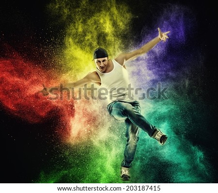 Man dancer showing break-dancing moves against colourful powder explosion