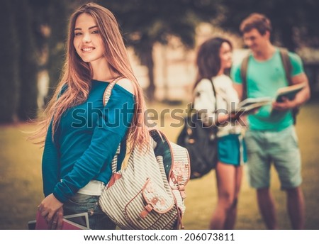 Beautiful young girl student in a city park on summer day
