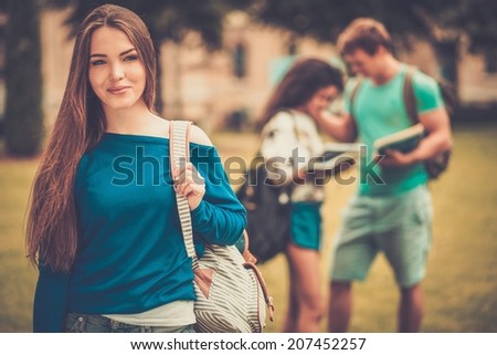 Beautiful young girl student in a city park on summer day