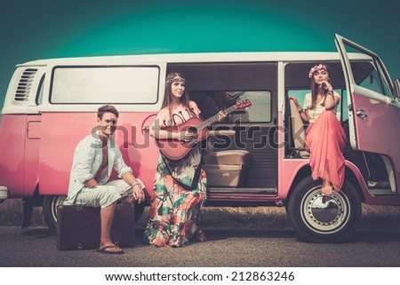 Young hippie friends with guitar on a road trip