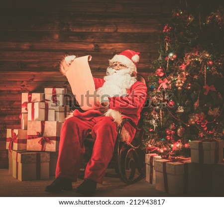 Santa Claus in wooden home interior reading wish list scroll