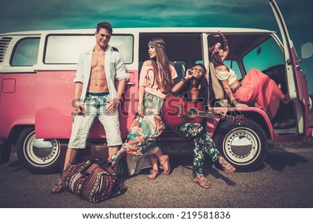 Multi-ethnic hippie friends with guitar on a road trip