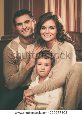 Family in warm cashmere clothes in home interior