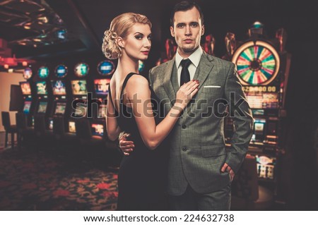 Well-dressed couple against slot machines