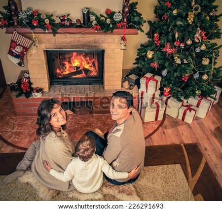 Family near fireplace in Christmas decorated house interior