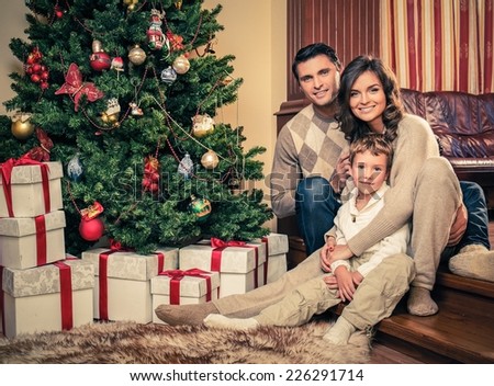 Happy family near Christmas tree in house interior