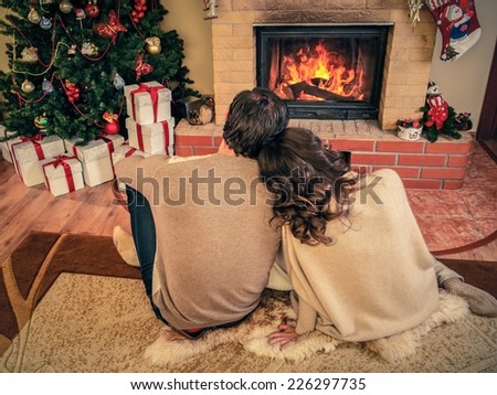 Couple near fireplace in Christmas decorated house interior