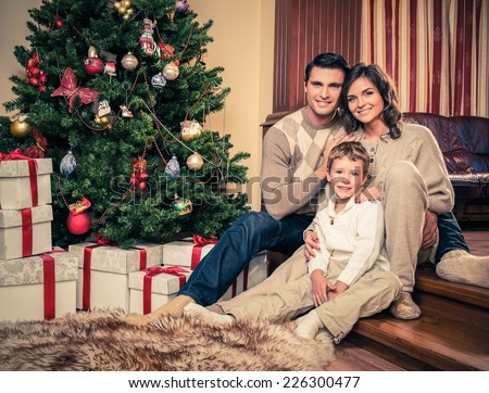 Happy family near Christmas tree in house interior