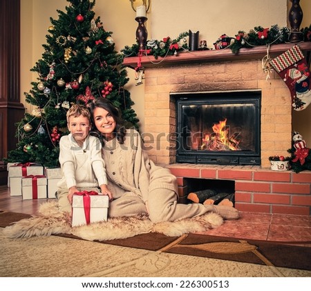 Happy mother with her son in Christmas decorated house interior